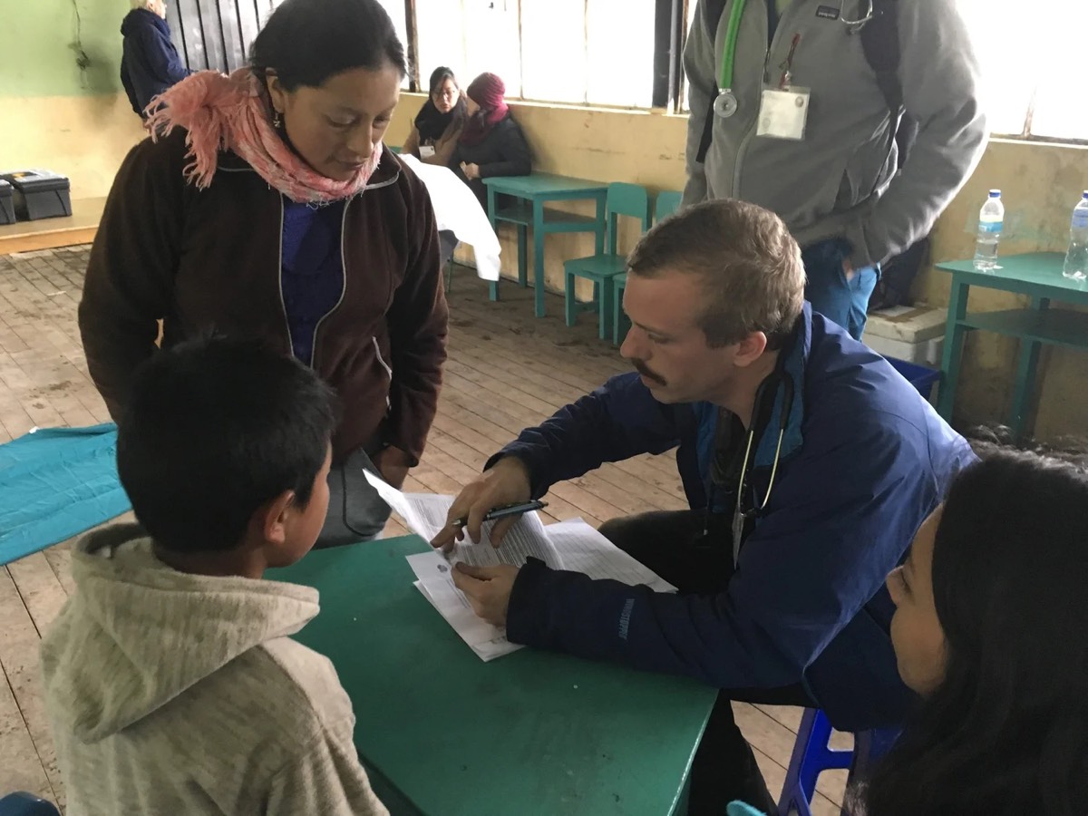 A physician taking notes with a patient at the consultation table