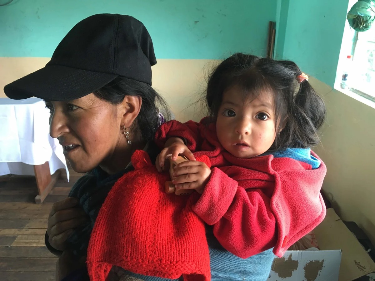 A mother holds her young child at the clinic